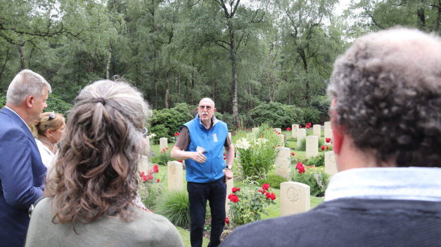 Guide sharing stories of soldiers in front of white gravestones