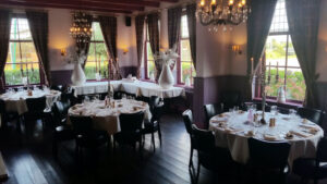 Large dining hall with round tables, set for a banquet