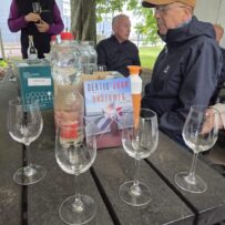 20260611_172638 Group of people listening to a talk about the city vineyard and tasting some of the wine. There is also a book shown - dertig jaar onderweg.