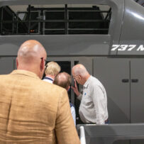 IMG_7660 People looking into a flight simulator.